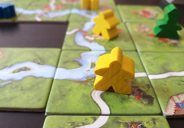 meeples on carcassonne board game board