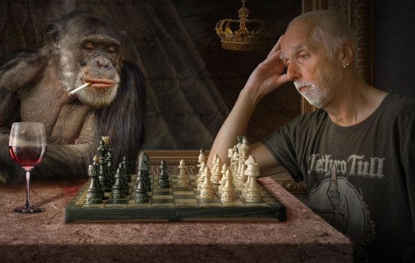 pensive man and monkey playing chess